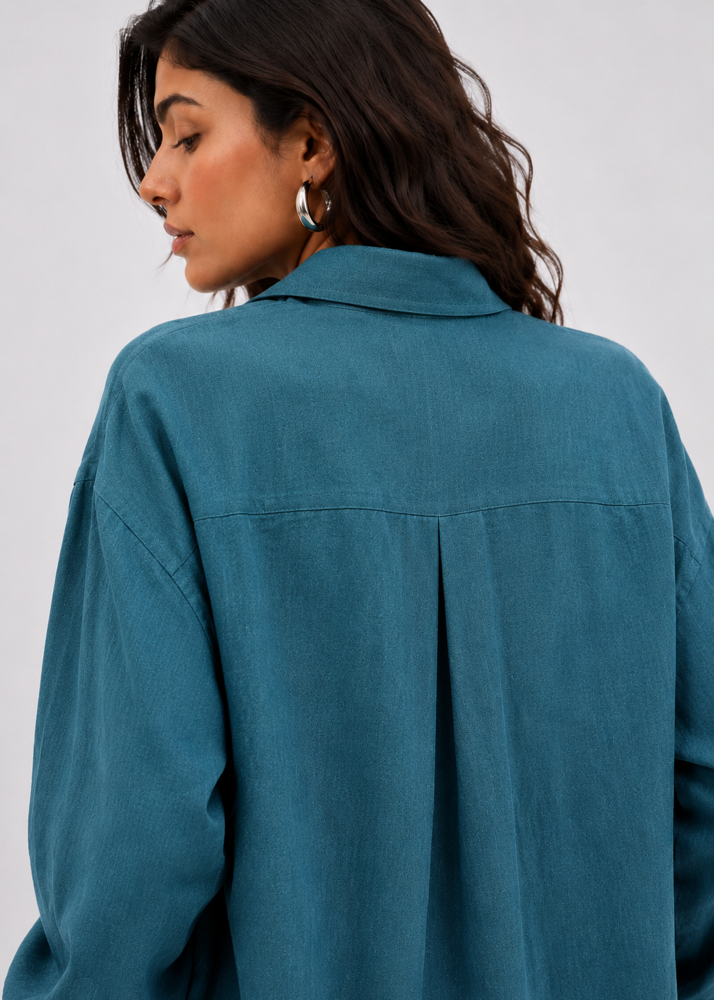 Person wearing a teal shirt against a white background