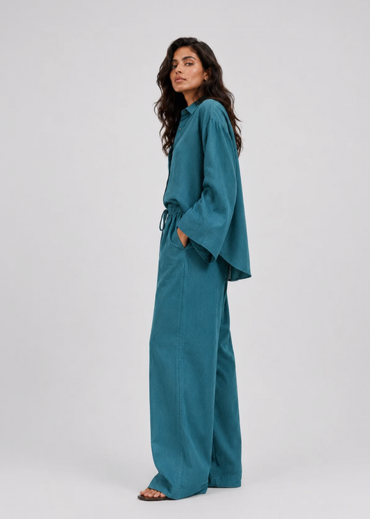 Woman wearing a teal outfit on a white background